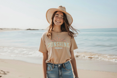 Beach-inspired shirt design featuring bold collegiate font and sun graphic, soft pastel tones and worn texture for a relaxed summer look