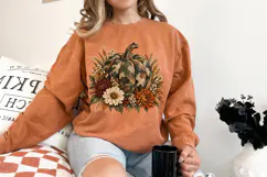 Camo fall pumpkin PNG surrounded by layered mums, cream blooms, berries, wheat and earthy foliage in a rustic orange, burgundy, olive and neutral palette.