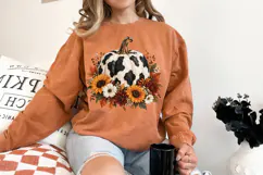 Single digital pumpkin graphic featuring black cow spots over creamy textured sections with a full border of fall flowers, berries and leaves arranged around the base.