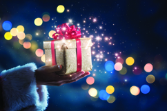 Santa Claus holding a golden gift box with a red ribbon Product Image 1