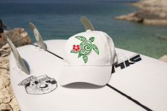 Stylized Hawaiian sea turtle illustration featuring decorative swirl details and a bold hibiscus flower accent. Clean vector-style artwork displayed on white for easy crafting and cutting machine use.