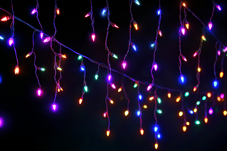 A string of colorful Christmas lights hanging in the dark