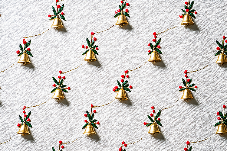 A festive Christmas garland with gold bells and red berries