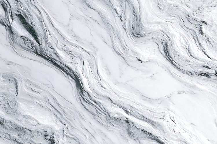 A close-up view of a white marble surface with gray veins