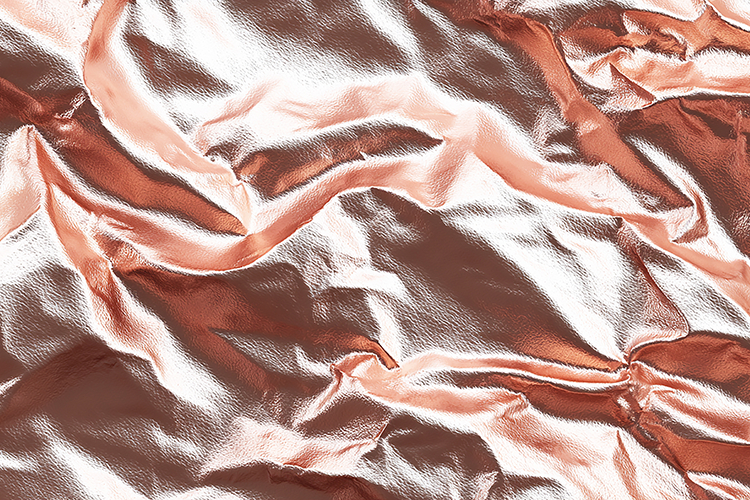 Crumpled metallic fabric with a shiny rose gold surface