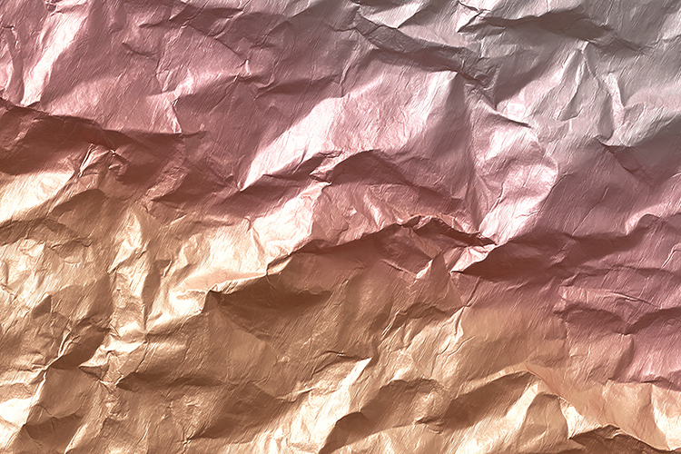Crumpled metallic paper in shades of pink and gold