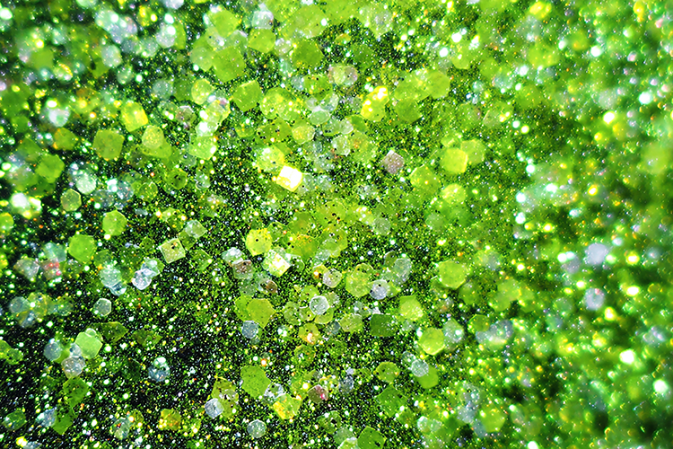 Sparkling green glitter background with shiny particles