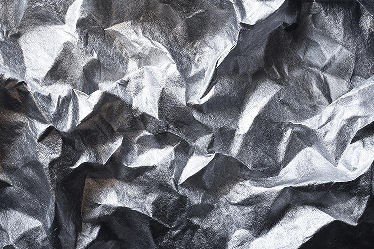 A close-up view of crumpled silver paper with textured folds