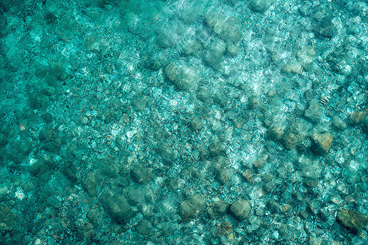 Clear Turquoise Water with Underwater Stones Texture