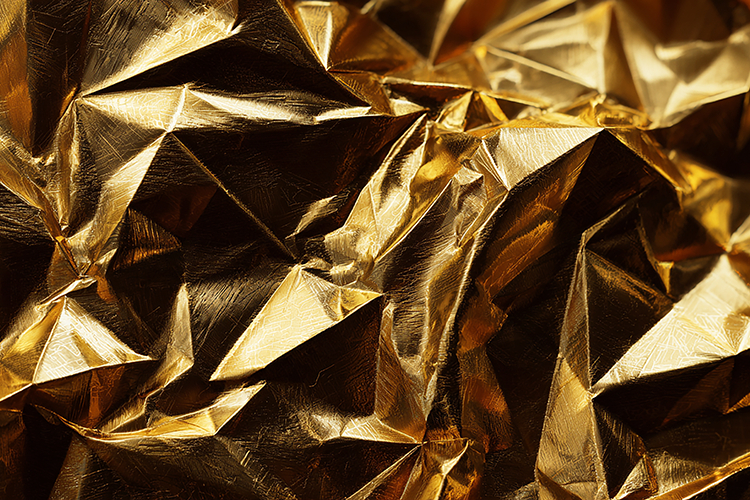 Crumpled gold foil with shiny, reflective geometrical shapes