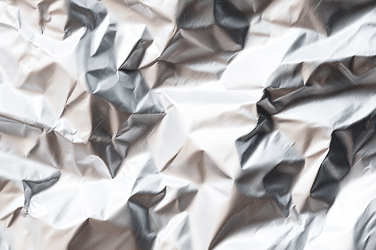 Crumpled silver foil with textured wrinkled surface