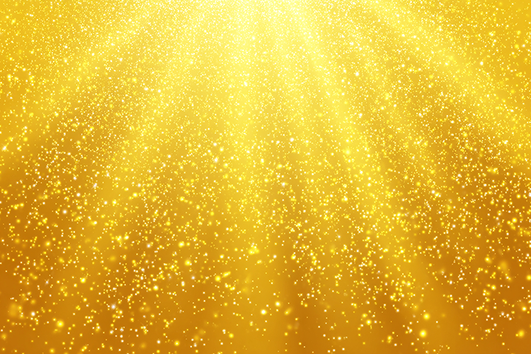 Golden background with sparkling particles and radiant light