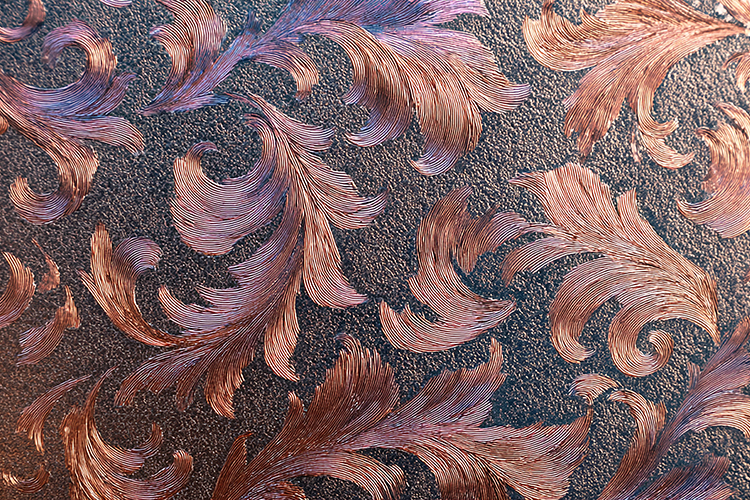 A textured surface with intricate copper and purple floral