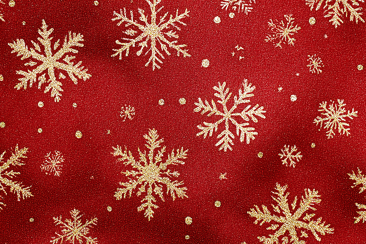 A vibrant red fabric with intricate gold snowflakes and dots
