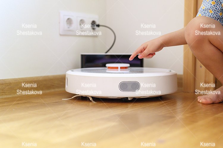 kids hand press button to turn the robot vacuum cleaner on example image 1