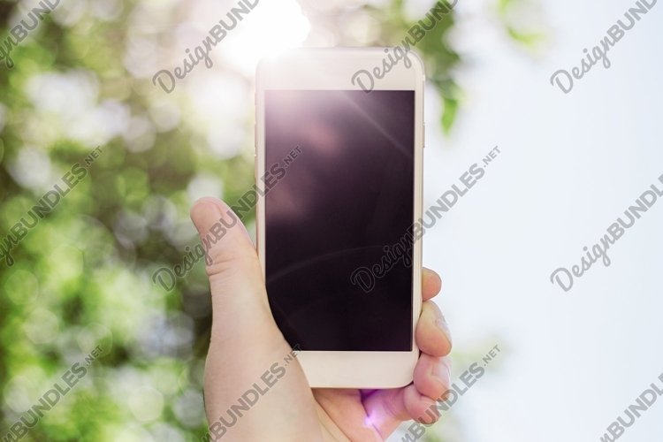 mobile phone in hand against the background of the sun example image 1
