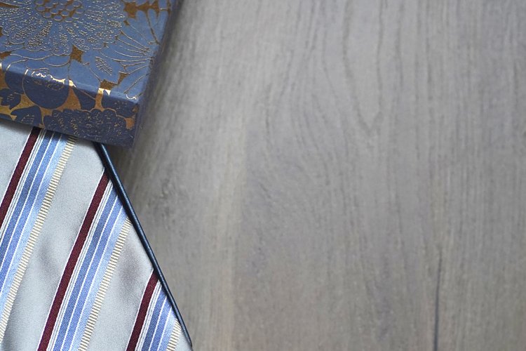 Roll up necktie on the table, a box of a present