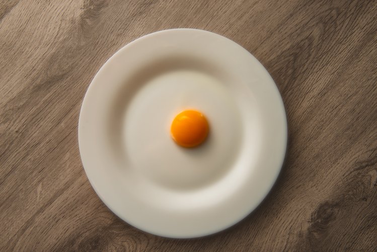 egg yolk on white plate and wooden table example image 1