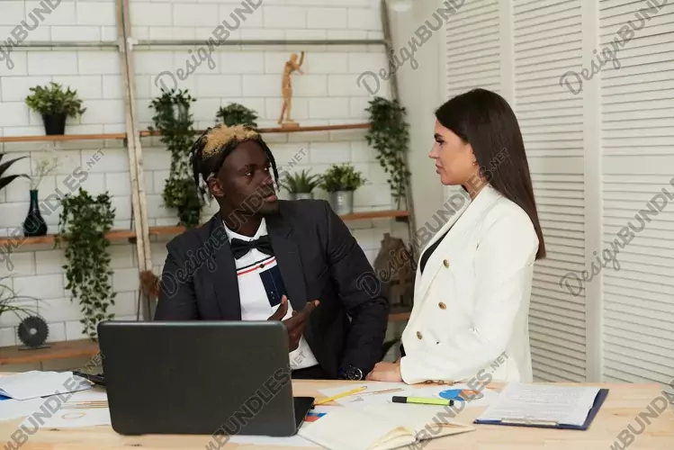 Close up of multiracial colleagues talking in office