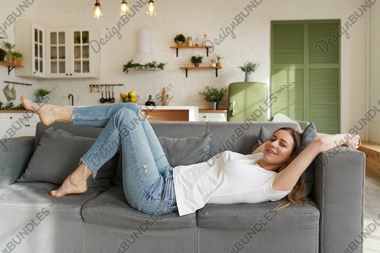 Young woman relaxing on the couch after a long day example image 1