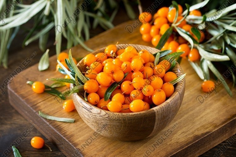 Fresh sea buckthorn berries in a wooden bowl. example image 1