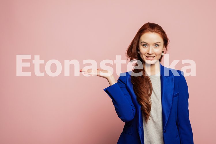 Woman showing pointing on pink background. example image 1