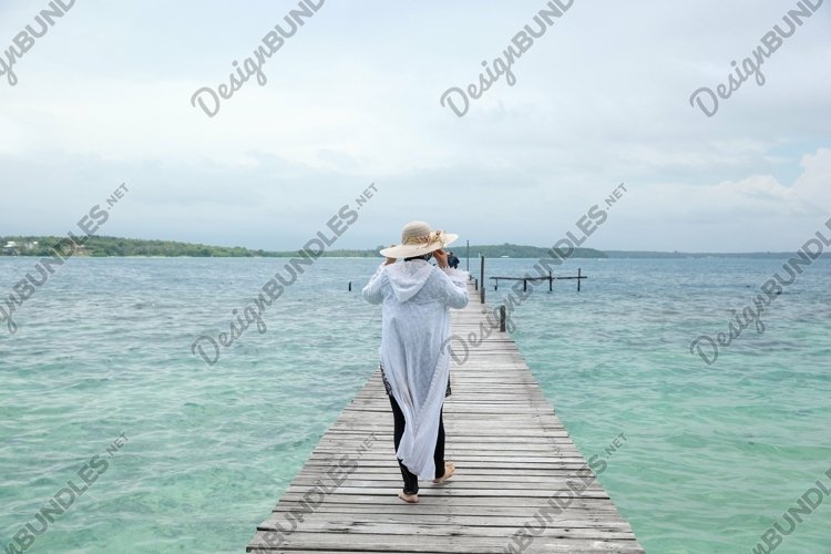Woman walking on wooden dock example image 1