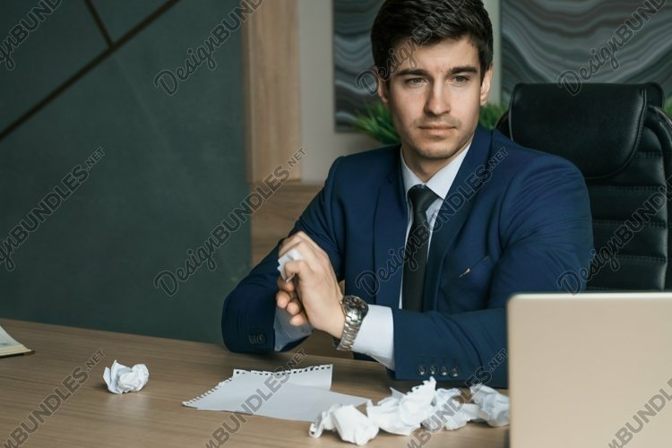 Angry businessman working with laptop in modern office. Crum example image 1