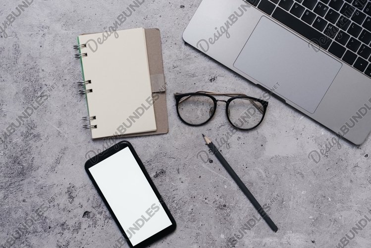 Mock up phone in modern office with laptop, notepad example image 1