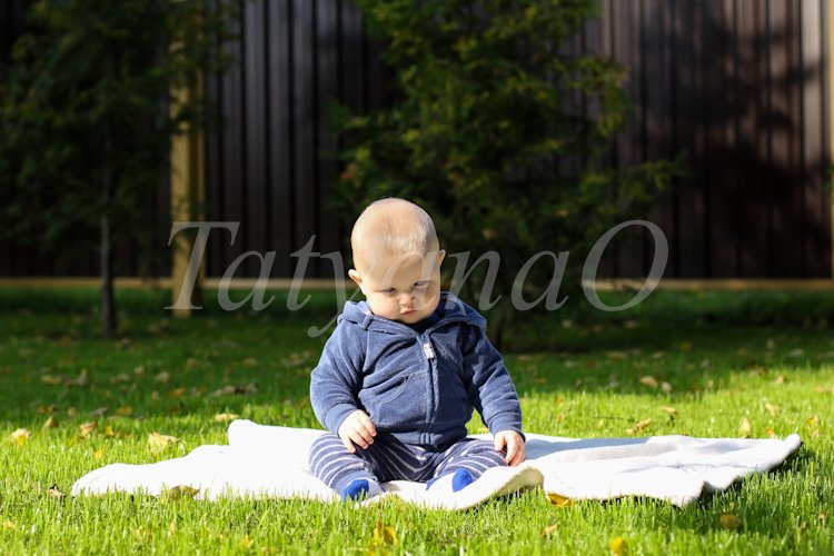 Portrait of a cute little boy sitting on a blanket example image 1