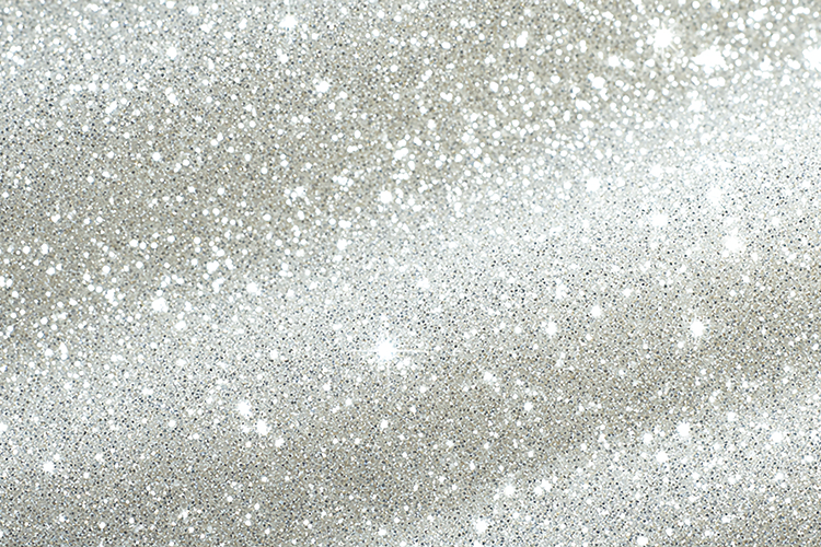 A sparkling silver glitter background with white specks