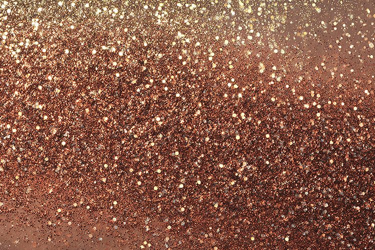 A brown glittery surface with gold sparkles
