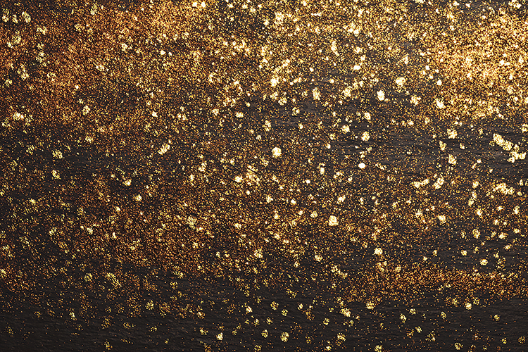 Gold glitter and specks on a black background