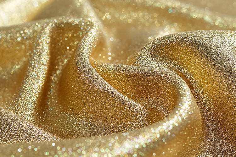 Gold glitter fabric with a smooth, shiny texture and folds