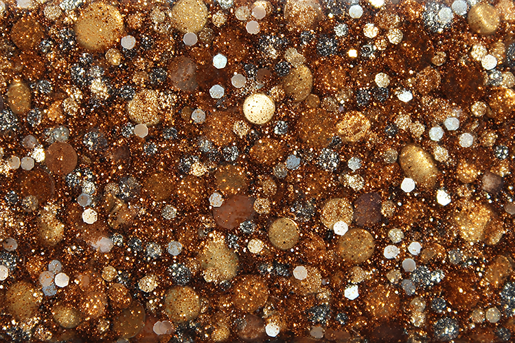A textured surface covered in shiny, metallic, and glittery