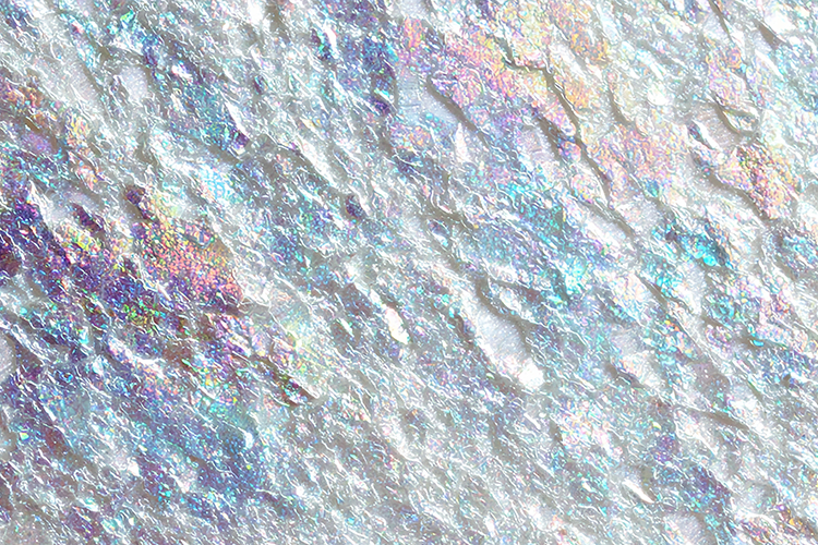 Iridescent surface with shimmering colors and a rough, bump