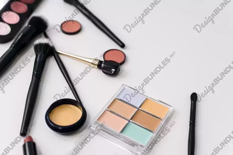 Eye shadow, makeup brushes, concealer and shadows on white