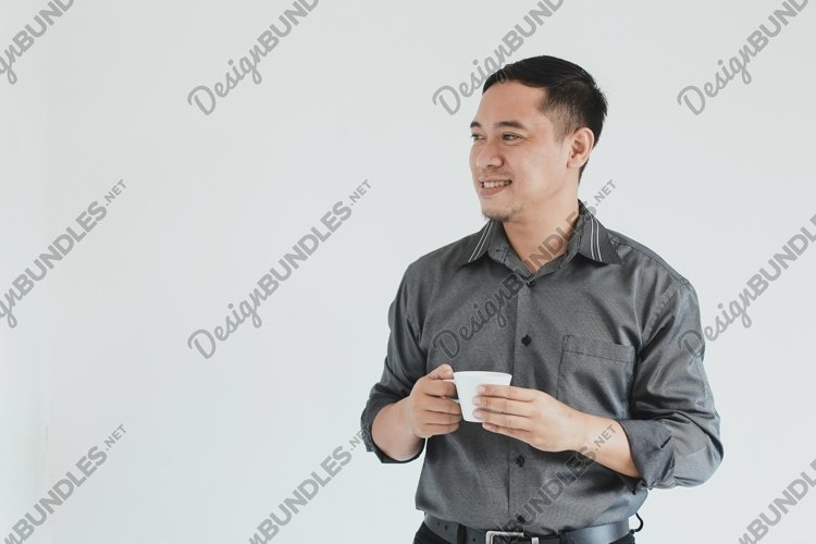 Businessman looking empty space while holding a coffee cup example image 1