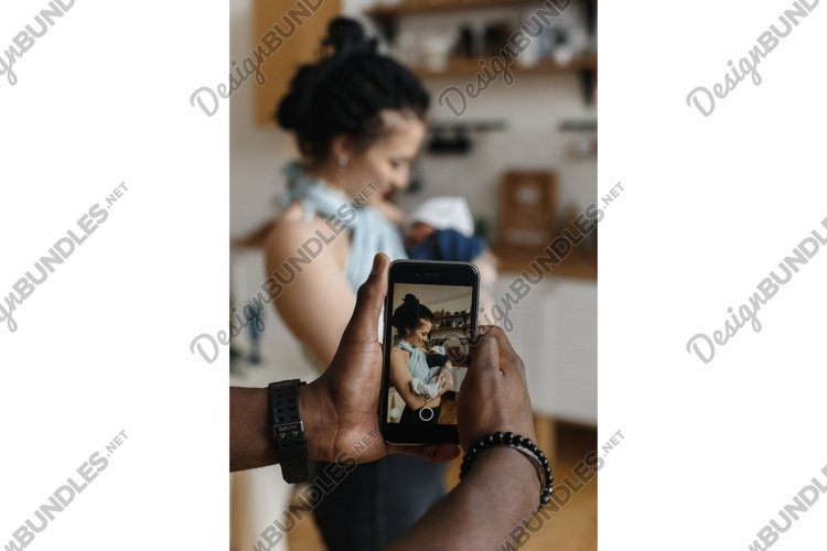 An African American man takes a photo of his Caucasian wife example image 1