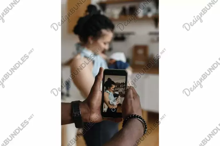 An African American man takes a photo of his Caucasian wife
