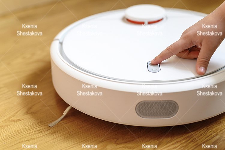 kids hand press button to turn the robot vacuum cleaner on example image 1