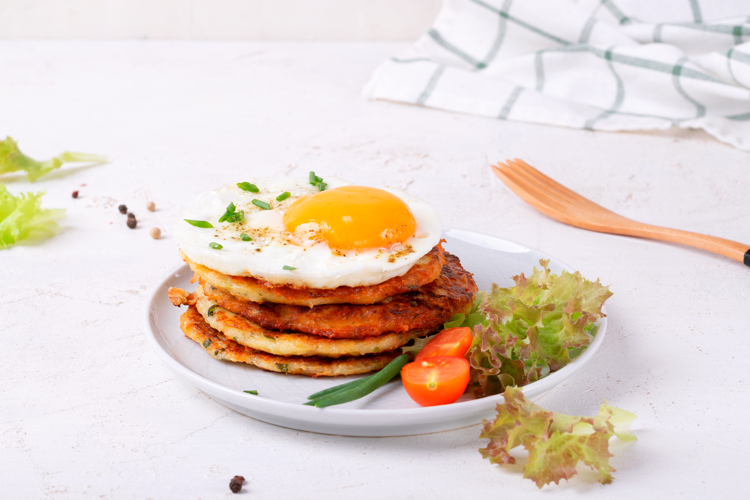 Fried egg on the stack of zucchini fritters