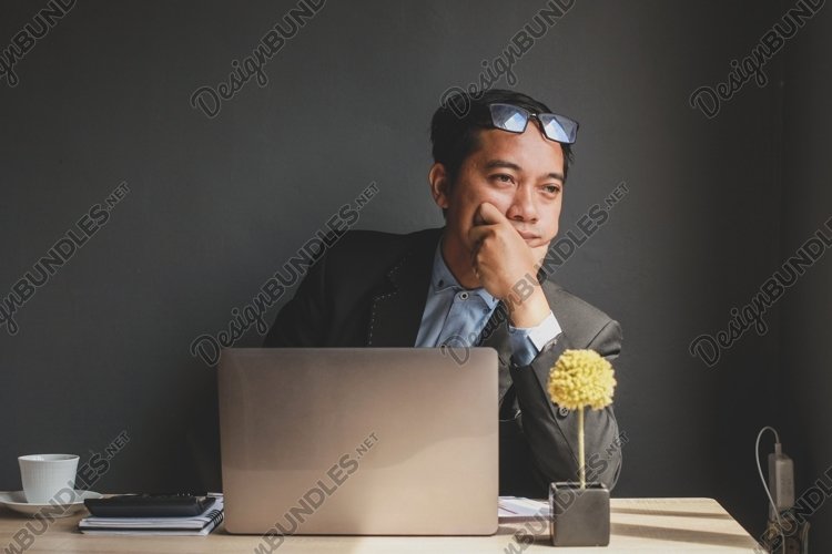 Businessman with hand raised on chin looking for idea