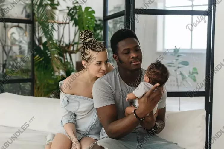 Young multiethnic family looks at the baby