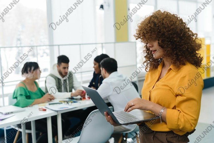 Woman working in laptop against the background of colleagues example image 1