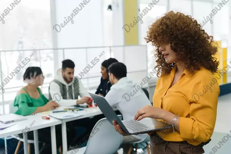 Woman working in laptop against the background of colleagues