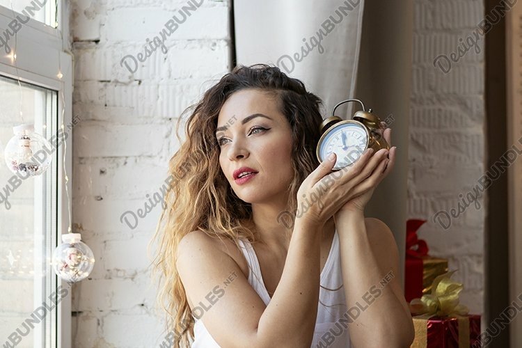 young girl in a beige plaid with watch in hands, new year example image 1