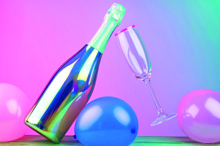 An iridescent champagne bottle with a flute glass