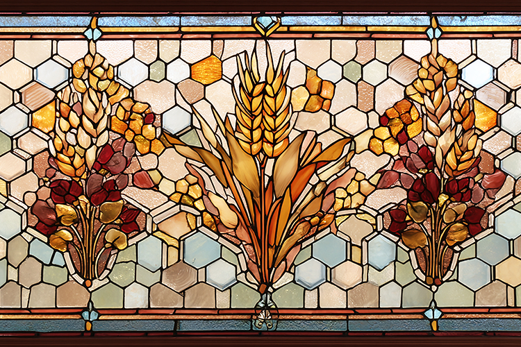 A beautiful stained glass window with wheat and flowers