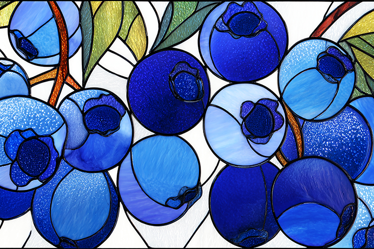 A stained glass artwork of blueberries with green leaves on